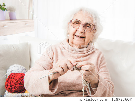 Smiling eldery woman knitting with colorful laces balls Smiling eldery woman knitting with colorful laces balls 118723607