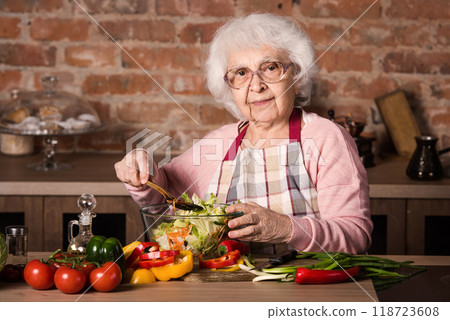 Senior woman cooking vegetable salad at the kitchen at home Senior woman cooking vegetable salad at the kitchen at home 118723608