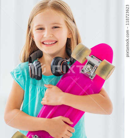 Beatiful kid holding her favorite pink skateboard for going for the walk 118723623