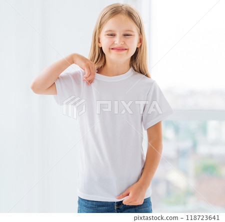 Smiling little girl showing her brand new white t-shirt Smiling little girl showing her brand new white t-shirt 118723641