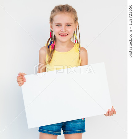 Little smiling girl showing blank white canvas banner for advertising 118723650