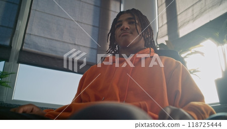 Unhappy African American teen boy discussing family problems on counseling session 118725444