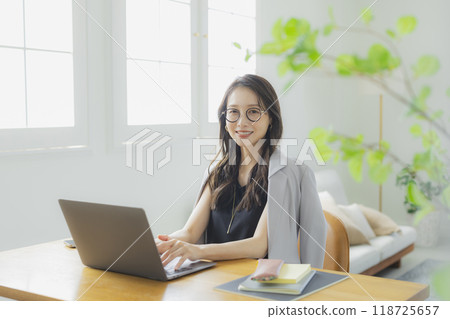 一位年輕女子在客廳在家工作 118725657