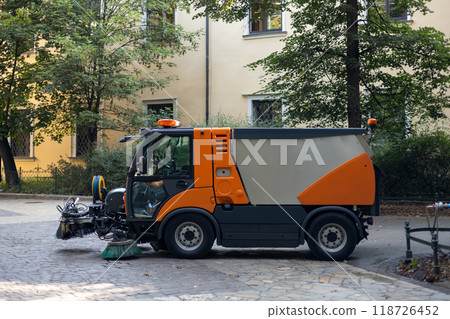 Municipal car for cleaning and brush roads or sidewalks outdoors. Steel Broom of Road Sweeper Car Machine. The concept of cleaning city streets, business, industry. 118726452