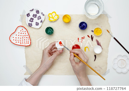 A woman paints clay products. Hobby clay modeling A woman paints clay products. Hobby clay modeling 118727764