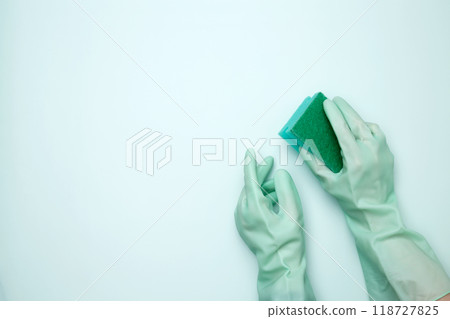 Womans hand in rubber glove holds dishwashing sponge. House cleaning. Copy space Womans hand in rubber glove holds dishwashing sponge. House cleaning. Copy space 118727825