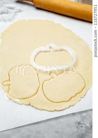 Making different shapes of fall cookies for Halloween. Dough with pumpkin shaped cookie cutter Making different shapes of fall cookies for Halloween. Dough with pumpkin shaped cookie cutter 118727951