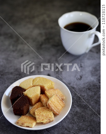 Sweets on a white plate and coffee in a white cup Sweets on a white plate and coffee in a white cup 118728115