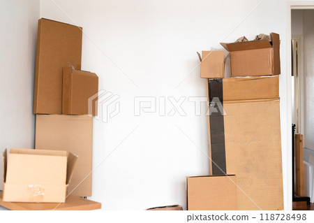 Creative minimalist image of stacked cardboard boxes on a plain background, representing concepts of moving, storage, shipping, and organization. Ideal for themes of simplicity and efficiency. Creative minimalist image of stacked cardboard boxes on a plain background, representing concepts of moving, storage, shipping, and organization. Ideal for themes of simplicity and efficiency. 118728498