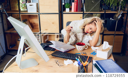 Tired employee, battling illness, still working. Overworking while sick can lead to poor results and longer recovery times. Tired employee, battling illness, still working. Overworking while sick can lead to poor results and longer recovery times. 118729355