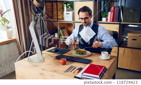 Serious approach to eating lunch at desk, completely prepared. While productivity key, taking real breaks away from desk crucial for it. 118729423