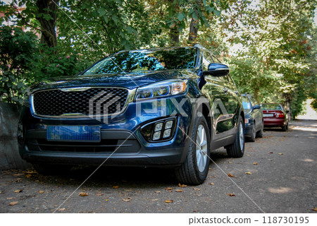 Beautiful car close-up. A dark KIA crossover stands in the driveway of the courtyard. 118730195
