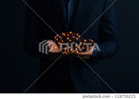 A person in a suit holds a glowing network of connections, symbolizing technology and innovation in a dark setting. A person in a suit holds a glowing network of connections, symbolizing technology and innovation in a dark setting. 118730225