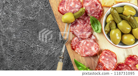 Antipasto board with salami and olives on stone background. place for text, top view 118731095