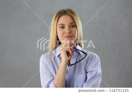 Attractive young woman posing in strict outfit hold black glasses 118731185