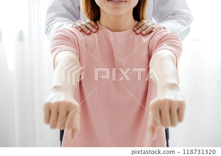 Female doctors rehab physical therapy by extending the pain hand of patient, treatment with stretch exercises 118731320