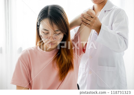 Female doctor hand rehab physical therapy by extending the pain shoulder of a patient. treatment with stretch exercises 118731323