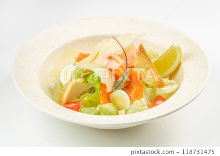 Caesar salad with salted salmon, lettuce, parmesan cheese with dressing on a light background, top view 118731475