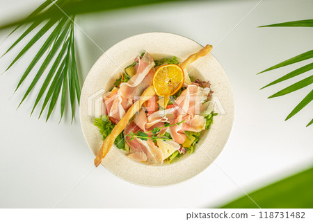 Fresh salad, juicy grapefruit, slices of cured Hamon meat, Brie cheese and grilled pineapple with honey-mustard dressing, copy space for text. top view Fresh salad, juicy grapefruit, slices of cured Hamon meat, Brie cheese and grilled pineapple with honey-mustard dressing, copy space for text. top view 118731482