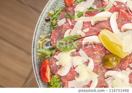 Traditional beef carpaccio with capers, arugula and parmesan served on a plate, copy space, top view 118731498