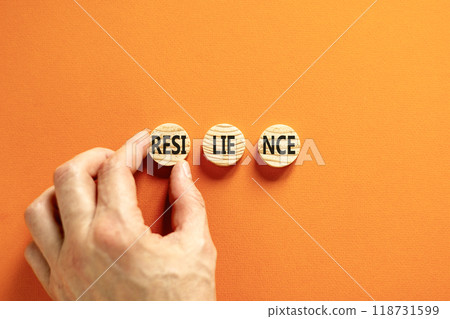 Resilience symbol. Concept word Resilience on beautiful wooden circles. Beautiful orange table orange background. Businessman hand. Business resilience concept. Copy space. Resilience symbol. Concept word Resilience on beautiful wooden circles. Beautiful orange table orange background. Businessman hand. Business resilience concept. Copy space. 118731599