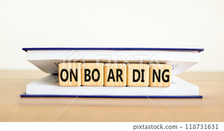 Onboarding success symbol. Concept word Onboarding on wooden cubes in book. Beautiful wooden table white background. Business onboarding success concept. Copy space. 118731631