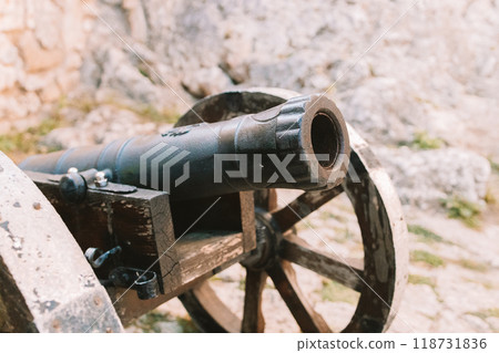 Cannon on a carriage located on a white stone pedestal near the arsenal building in Mirow Castle. Sites of Poland. Architecture of World Tourism. 118731836