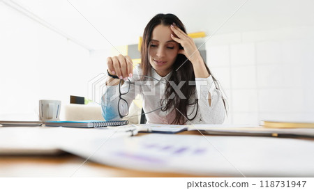 Tired overworked woman suffer with headache on workplace in office 118731947