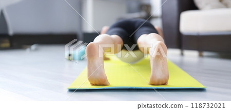 Person barefoot feet on mat performing exercise in morning for health 118732021