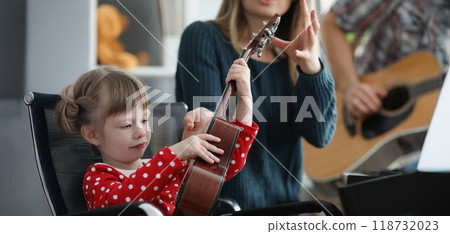 Mother take musical instrument from daughter hands to show how to play Mother take musical instrument from daughter hands to show how to play 118732023