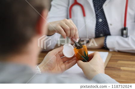 Doctor give bottle with dried cannabis to patient for health treatment 118732024