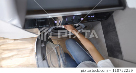 Woman hands load washing machine with dirty clothes or taking out clean 118732239