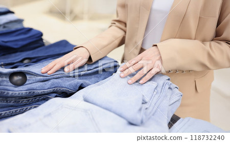 Woman choose jeans in trendy store, decide between different colours 118732240