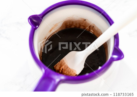 Melting vegetable shortening and cocoa powder in the candy melting pot creates a perfect mixture for greasing the bundt cake pan. Melting vegetable shortening and cocoa powder in the candy melting pot creates a perfect mixture for greasing the bundt cake pan. 118733165