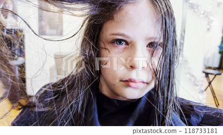 Gentle hands maneuver a hair dryer through a young girl's newly cut hair, showcasing the drying process after a meticulous trim. The warmth of the dryer breathes life into her locks, as they transform Gentle hands maneuver a hair dryer through a young girl's newly cut hair, showcasing the drying process after a meticulous trim. The warmth of the dryer breathes life into her locks, as they transform 118733181