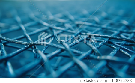 A detailed close-up of a blue woven fabric, showcasing the intricate texture and intersecting threads. The fabric appears strong and durable. 118733788