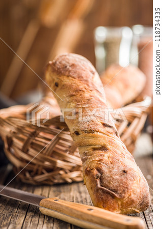 Crusty rustic baguette on wooden table. 118734335