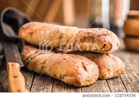Crusty rustic baguette on wooden table. 118734336