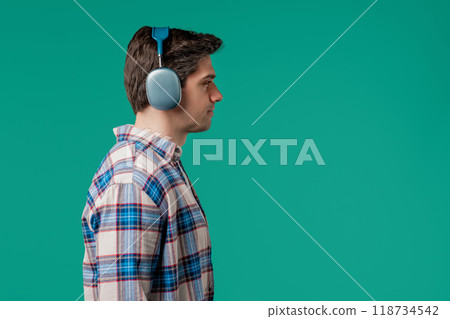 Positive handsome man listening music,enjoying with modern headphones,copy space Positive handsome man listening music,enjoying with modern headphones,copy space 118734542