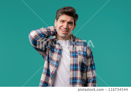 Tired casual man feeling pain in neck joint, massaging muscles, rubbing head 118734544