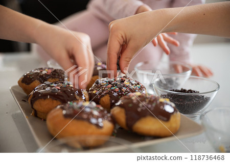 Children decorating home made doughnuts 118736468