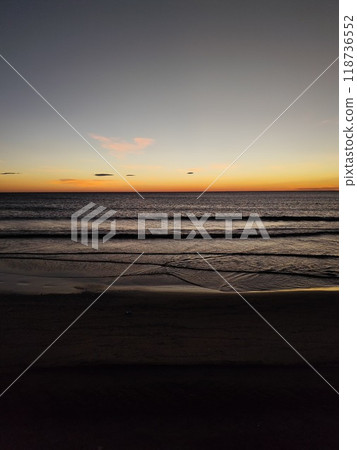 Sunrise. Dawn. Dawn in the sea. Sunrise in the sea. The first rays of sunlight rising through the sea water leaving a colorful, orange sky. Sun rays reflected in the waves of the sea. 118736552