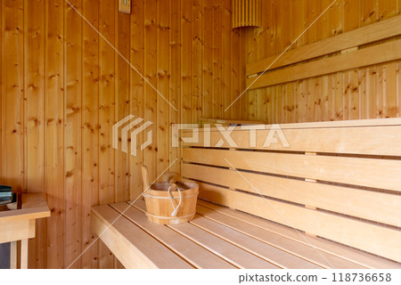 Wooden Sauna With Benches. The sauna is empty. The wooden benches provide seating for people. Wooden Sauna With Benches. The sauna is empty. The wooden benches provide seating for people. 118736658