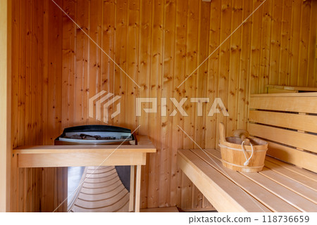Wooden Sauna With Benches. The sauna is empty. The wooden benches provide seating for people. 118736659