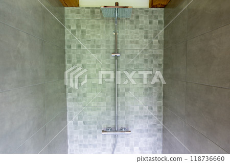 Modern bathroom with a big shower and gray tiles on the walls. 118736660