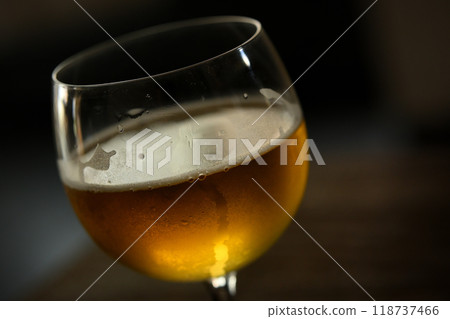 Half-drunk beer in a wine glass Half-drunk beer in a wine glass 118737466