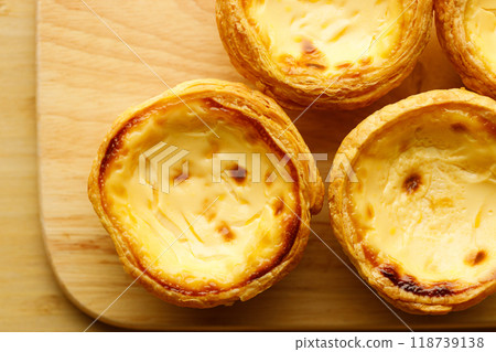 Stack of Portuguese sweet dessert egg tart or Pastel de Nata on wooden board on wooden table.  Selective focus. Top view. 118739138