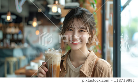 Young woman drinking iced cafe au lait in a bright cafe 118739995