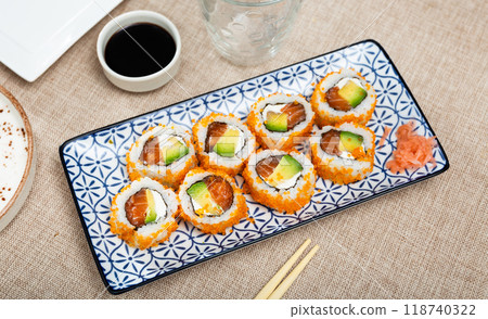 Plate is filled with California rolls with masago. 118740322