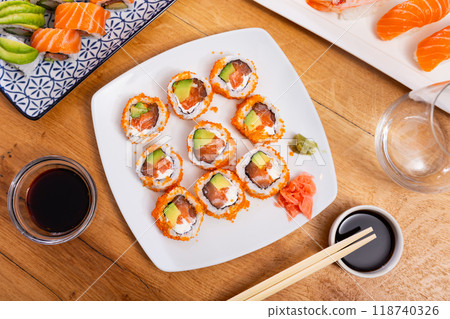 Plate is filled with California rolls with masago. Plate is filled with California rolls with masago. 118740326